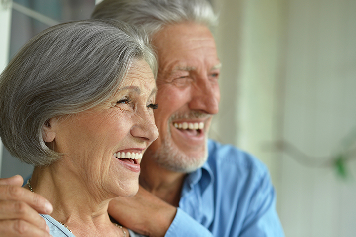 An image of a couple smiling with dental implants.